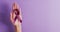 Video of hands of caucasian woman holding purple ribbon on violet background