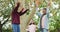 Video of happy african american mother, daughter and grandmother throwing autumn leaves in garden