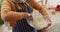 Video of happy biracial woman in hijab baking in kitchen, mixing cake batter holding mixing bowl