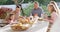 Video of happy caucasian parents, daughter and grandparents sitting at outdoor table for family meal