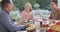 Video of happy caucasian parents, daughter and grandparents talking at outdoor dinner table