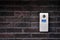 Video intercom on dark brick wall background. Modern, luxury, wealthy home security system. Alarm door bell. Safe entrance