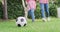 Video of low section of biracial mother and daughter playing soccer in garden