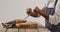 Video of mid section of african american man grating parmesan cheese onto wooden board on table