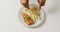 Video overhead shot of african american hands eating fish and chips on white plate with copy space