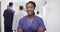 Video portrait of african american female doctor smiling in busy hospital corridor, copy space