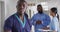 Video portrait of smiling african american male medical worker in busy hospital corridor