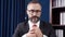 Video Portrait Zoom in, a bearded leader wearing glasses and a suit sitting in the office.