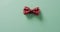 Video of red dotted bow tie lying on green background