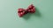 Video of red dotted bow tie lying on green background