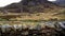 Video, Rugged Mountains with dry stone wall, stream  in foreground as if from moving car Left to Right.