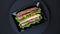 Video of tasty sandwiches rotating on dark background