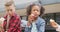 Video of three diverse schoolchildren eating packed lunches, talking in schoolyard