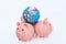 Video of Three pink piggy banks with the globe / Earth on their back isolated against white background