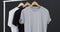 Video of three white, black and grey t shirts on hangers and copy space on black background