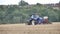 Video of tractor rotovating field of stubble and planting seeds