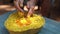 Video of unrecognizable mature woman hands washing finger skin in yellow, orange flower petal water in heart shaped bowl