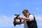 A videographer shoots video on a city street. Television journalist, reporter, correspondent with camera and stabilizer makes a