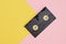 videotape on pink and yellow background, vintage video cassette copy space