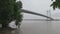 Vidyasagar Setu or Second Hooghly Bridge over the Hooghly River against overcast sky on a rainy day with framing tree in