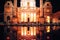 Vienna, Austria. Karlskirche at night with water reflection and people sitting around.