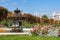 Vienna, Austria - October 2021: Fountain in Volksgarten park with Burg theater at background