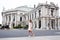 Vienna State Theater Burgtheater, Austria. A girl in a pink dress stands on the background of the building.