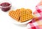 Viennese waffles, raspberry jam in a glass bowl on a white background