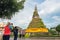 Vientiane, Laos: several travelers take pictures of a stupa That Dam and pose in front of it.