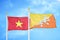 Vietnam and Bhutan two flags on flagpoles and blue sky