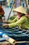 VIETNAM, HO CHI MINH - Vietnamese Woman Weaving Yarn On Street