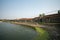 Vietnam landscape with pond and old aged houses and woman cycling on road in village