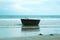 A Vietnamese basket-boat on a beach, resting near a pair of shoes on the sand.