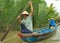 Vietnamese couple rowing on a boat along one of the tributaries of Mekong River near My Tho, Vietnam.