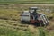 Vietnamese farmer pick rice up with a combine harvester