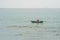 Vietnamese fisherman swims in a boat over the raging sea