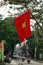 Vietnamese flag closeup with view on a street of city with motorcyclists