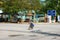 Vietnamese little girl riding bike cross road from school at noon