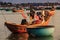 Vietnamese Man Dries Clothes on Flagstaff in Boat by Beach