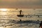 Vietnamese marine lifeguard in a traditional round woven bamboo boat watches people swimming in the permitted area in sea on the