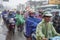 Vietnamese riders keep on going under the rain on a street of Ho Chi Minh City, Vietnam