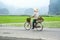 Vietnamese woman at conical hat on bicycle. Ninh Binh, Vietnam