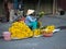 Vietnamese Woman with Conical Straw Hat Selling Gold Chrysanthemums