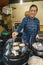 Vietnamese woman cooking Banh xeo - Vietnamese crepes or vietnamese pancake make from rice flour and filled with a shrimp meat