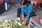 A Vietnamese woman is cutting coconut for travellers on a treet vendor