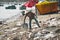 Vietnamese woman throws garbage on the beach by the sea. Dump by the sea. bad ecology in Southeast Asia. Fishermen village in MUI