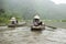 Vietnamese woman in traditional conical hat rows boat into natural cave on Ngo river, Tam Coc, Ninh Binh, Vietnam