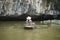 Vietnamese woman in traditional conical hat rows boat into natural cave on Ngo river, Tam Coc, Ninh Binh, Vietnam