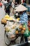 Vietnamese woman wearing asian conical hat sell fruits on her bicycle at street of Hanoi, Vietnam