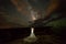 A Vietnamese woman in a wedding dress poses in the barren desert of Moab, Utah at night.